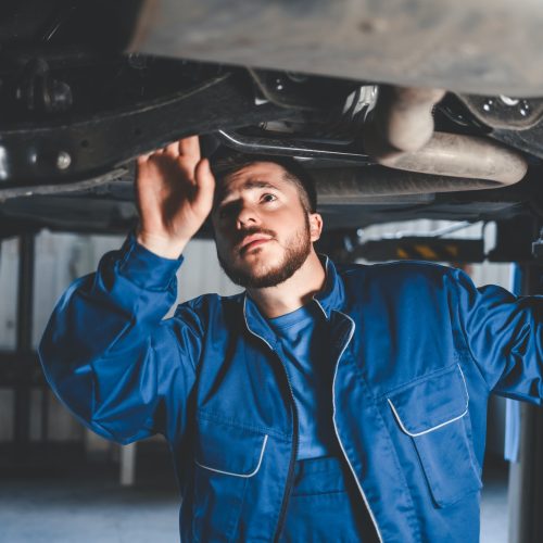 Auto mechanic inspects car suspension. Diagnostics of the condition of the car